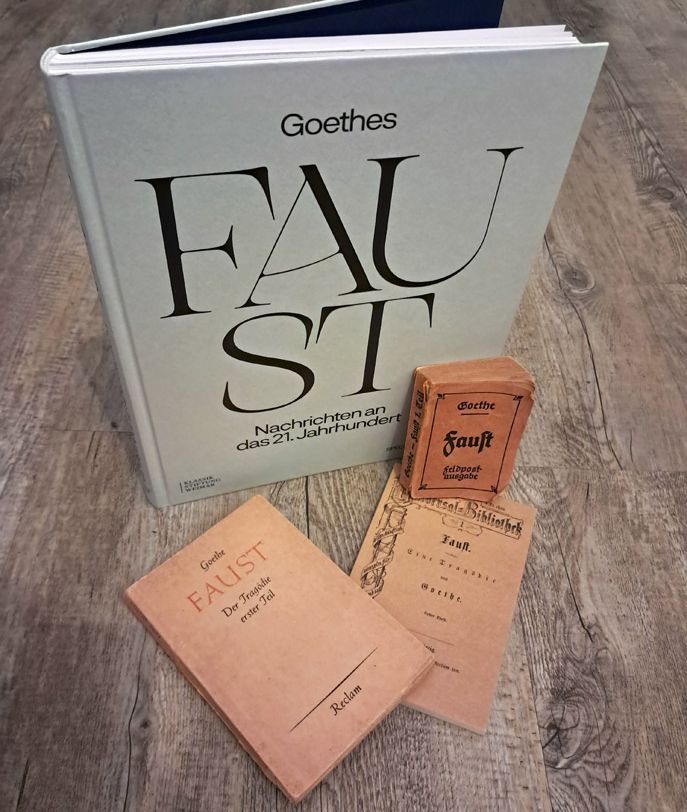 Der besprochene Band "Goethes Faust. Nachrichten an das 21. Jahrhundert" und diverse Faust-Ausgaben.