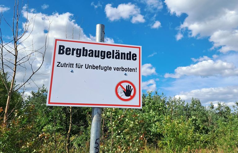 Ein Warnschild mit der Aufschrift "Bergbaugelände - Zutritt für Unbefugte verboten!"
