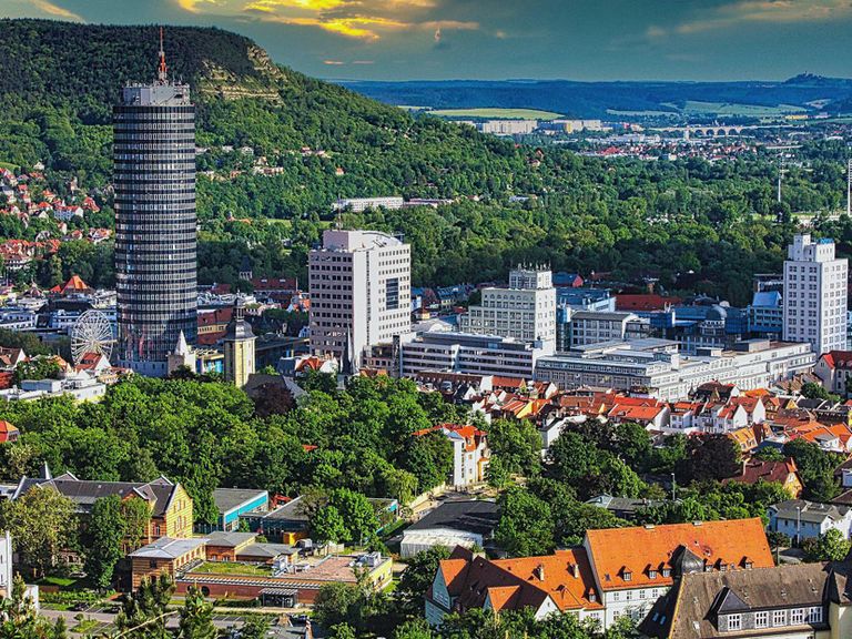 Ein Blick auf die Innenstadt von Jena mit dem Uniturm und mehreren Hochhäusern.