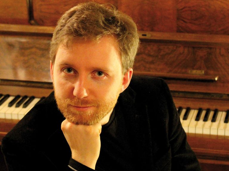 Ein Foto zeigt Stummfilmpianist Richard Siedhoff vor dem Klavier.