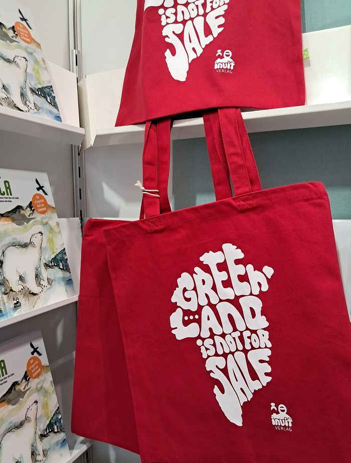 Ein Roter Stoffbeutel mit der Aufschrift "Greenland is not for sale" am Messestand des Inuit-Verlags